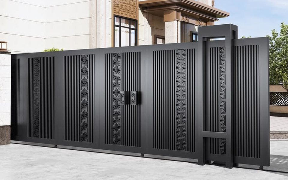 Black sliding gate with slatted panels and a pedestrian door