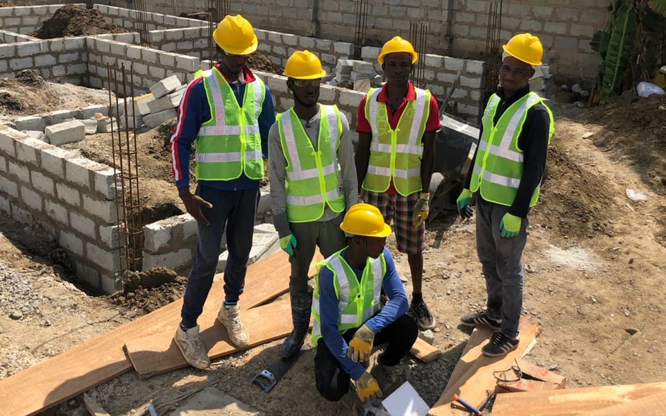 ENS Creatives site team in hard hats and safety vests at a block foundation