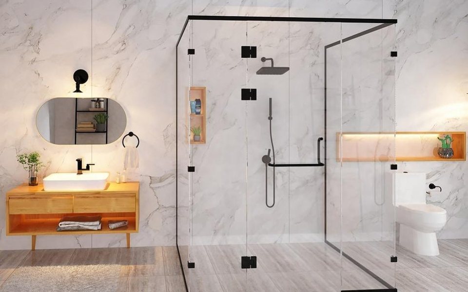 Frameless glass shower enclosure with black hardware in a marble bathroom