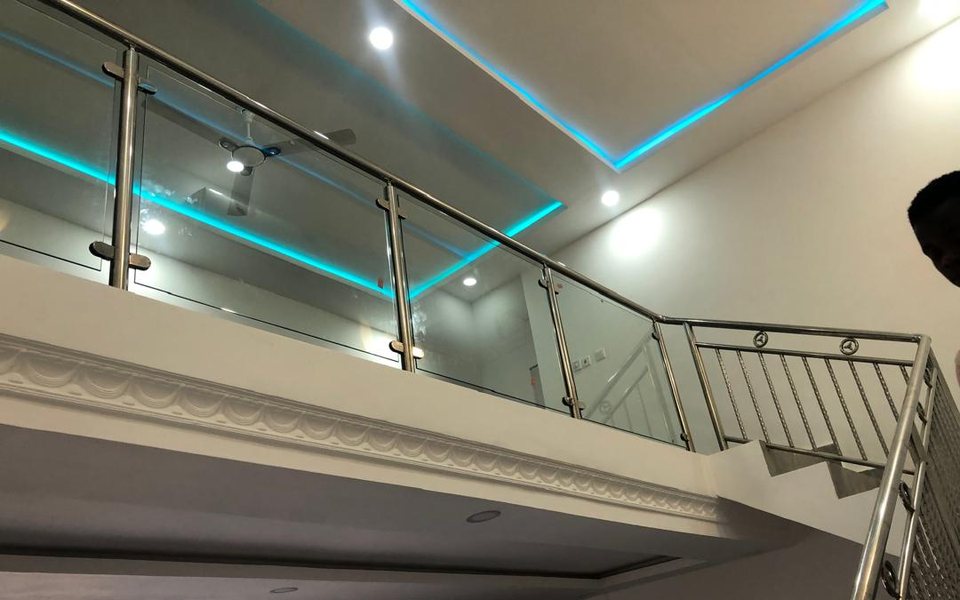 Glass and stainless steel mezzanine railing under blue LED ceiling lights