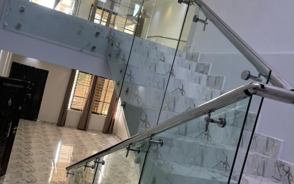 Glass and stainless steel staircase railing with marble steps