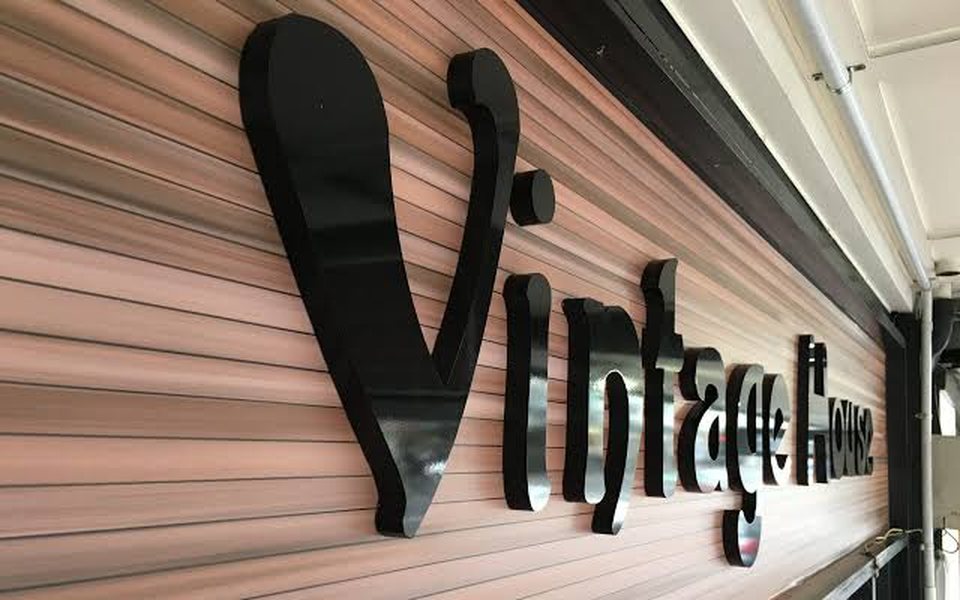 Gloss black 3D lettering on a timber-effect wall