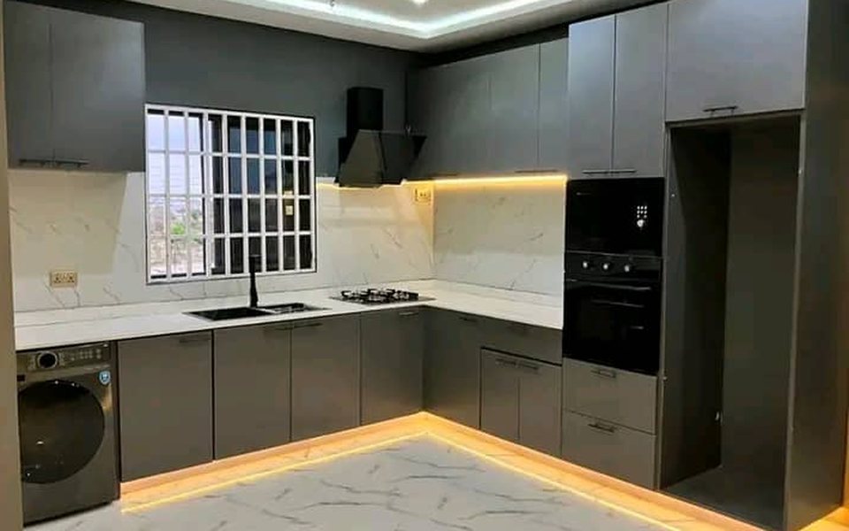 Modern grey kitchen with LED lighting and a marble-effect splashback