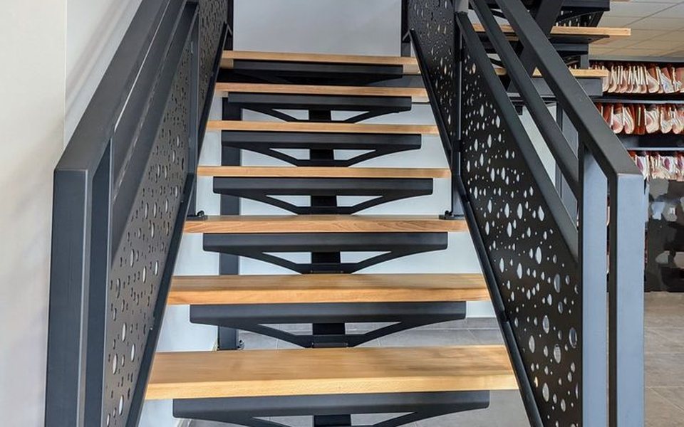 Staircase with perforated steel railing panels and timber treads