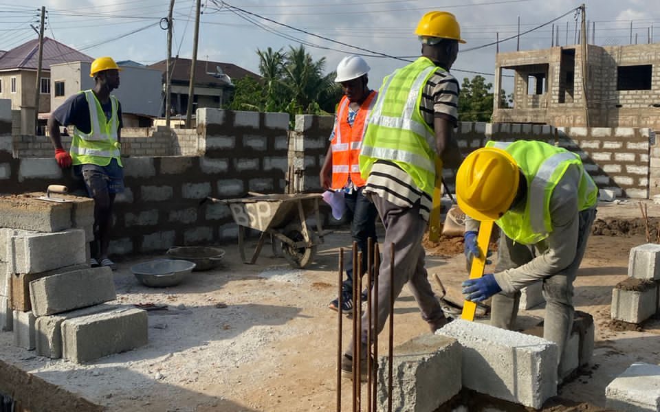Workers laying concrete blocks on a building site